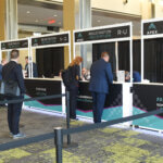 Executives lining up in front of registration booths at the APEX summit 2023